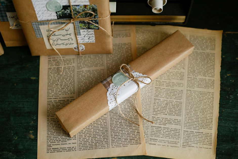 Elegantly wrapped vintage gifts resting on aged newspaper pages.